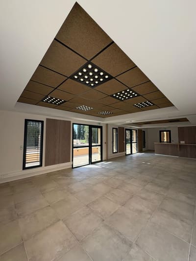 Salle de bureaux équipée après travaux, éclairage encastré allumé