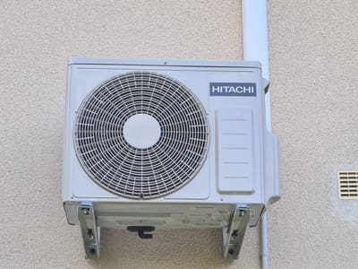 Groupe extérieur de climatisation posé sur une façade provençale